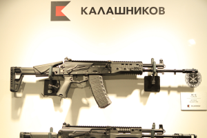 Zwei Sturmgewehre auf der Waffenmesse ausgestellt mit einer informativen Tafel an der Wand dahinter.