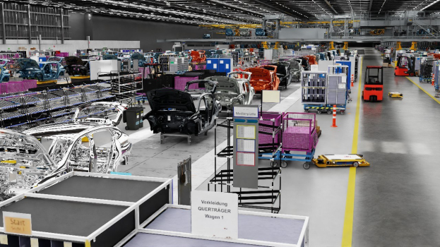 Eine große Volkswagen-Fabrik-Montageanlage mit zahlreichen Autos in der Produktion, Metallstrukturen auf beiden Seiten, einer Wand im Hintergrund und an der Decke angebrachten Leuchten.