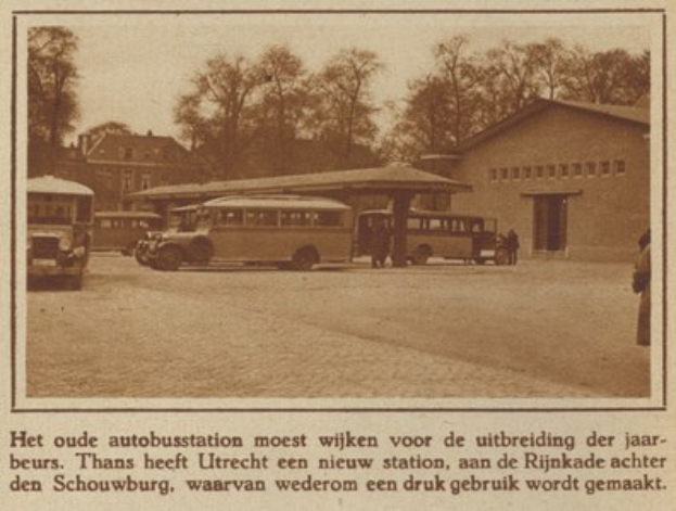 Altes Schwarz-Weiß-Foto eines Busbahnhofs mit mehreren geparkten Bussen, Menschen drumherum, Bäumen und Gebäuden im Hintergrund und Text unten.