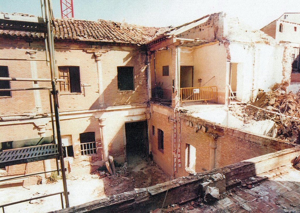 Teilweise abgerissenes Gebäude mit Barrikade, sichtbaren Fenstern und einem Gegenstand, der wie eine Leiter aussieht.