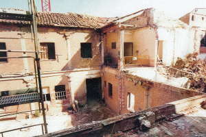 Teilweise abgerissenes Gebäude mit Barrikade, sichtbaren Fenstern und einem Gegenstand, der wie eine Leiter aussieht.