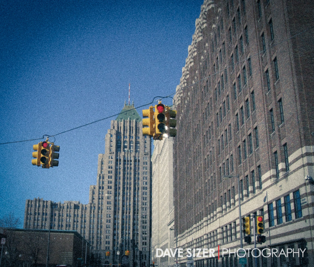 Mehrere Ampeln auf Masten vor Gebäuden montiert.