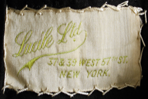 Ein Detailbild eines Stoffs mit einem Etikett, das wahrscheinlich den Namen des Kleidungsstücks anzeigt.