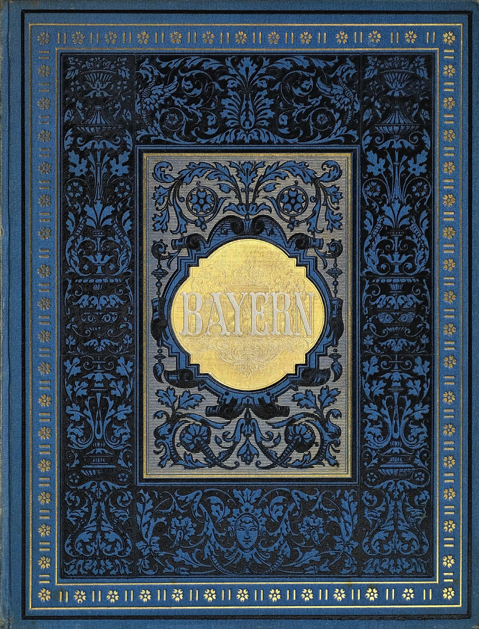 Ein blau-goldenes Buch mit dem Wort "Bayern" auf dem Cover, das mit detailreichen Verzierungen geschmückt ist.