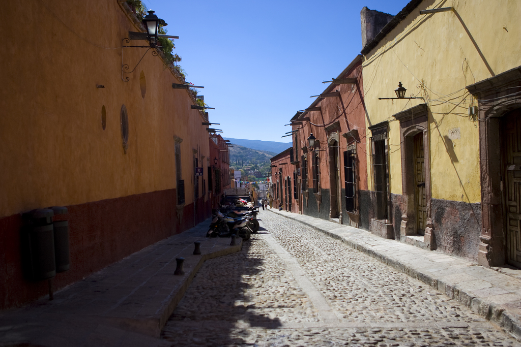 Gebäude säumen eine Straße, auf der einige Menschen Fahrrad fahren.