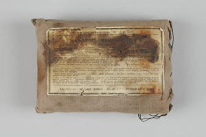 Ein kleiner Beutel mit einem Stück Papier darauf, wahrscheinlich ein Verbandskasten, mit Text darauf.