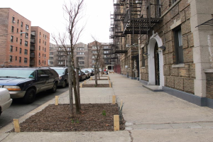 Eine spärlich bebaute Szenerie mit wenigen Autos und Gebäuden in der rechten Ecke und einigen anderen Gebäuden in der linken Ecke.