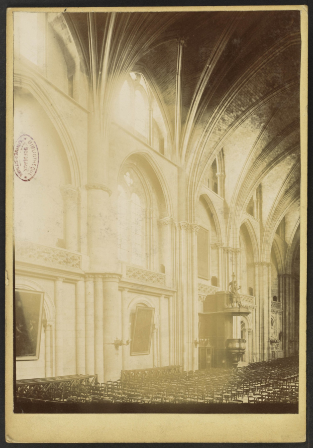 Altes Schwarz-Weiß-Foto eines Kircheninneren mit Bögen, Säulen, Wandrahmen und einer Decke, mit verstreuten Objekten, die Größe und Geschichte vermitteln.