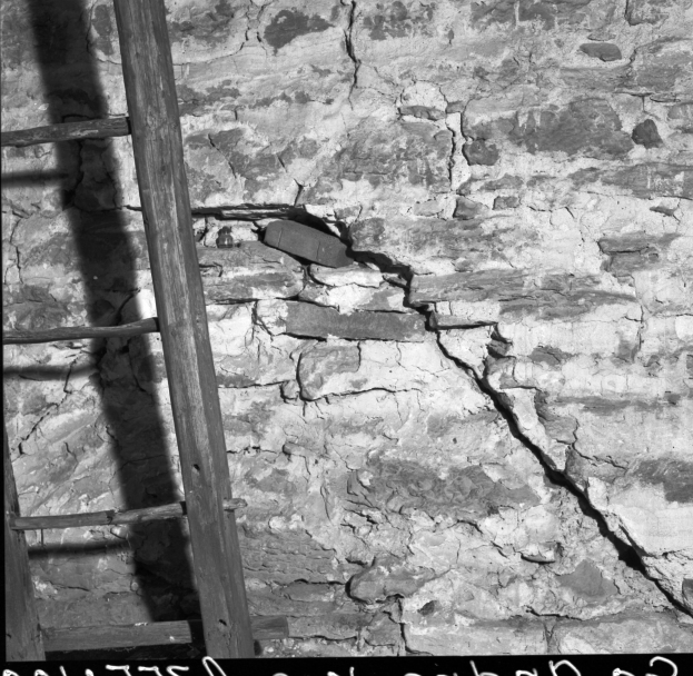 Schwarz-weiß-Foto einer Leiter, die an einer zerbrochenen Wand lehnt, mit Text am unteren Rand.