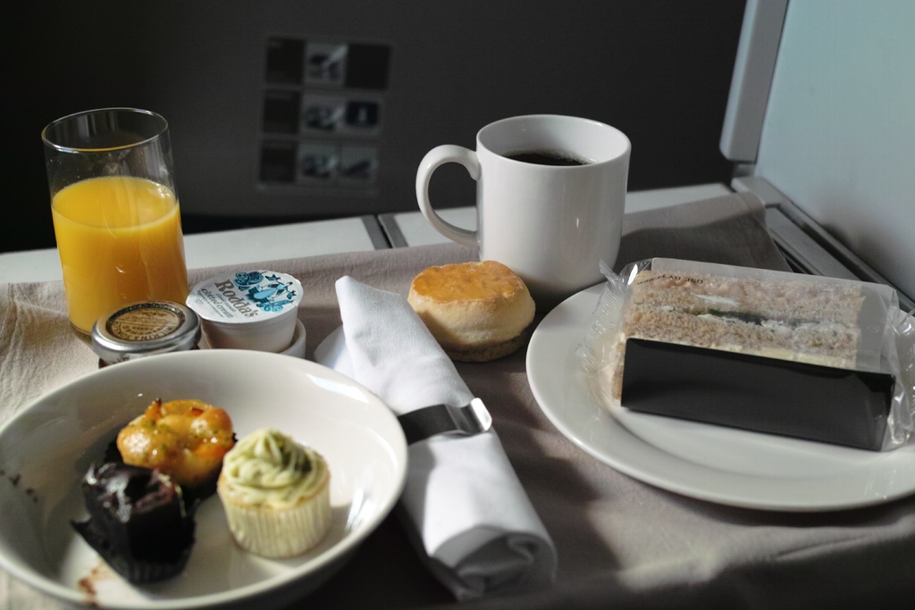 Ein Tischgedeck mit Tellern, Speisen, einem Becher, einem Glas und einem Tuch.
