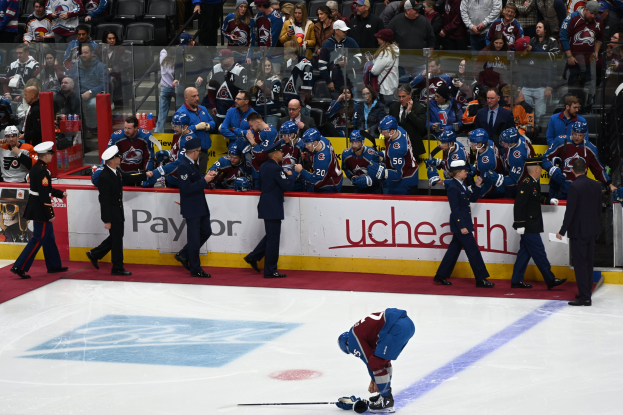 Hockeyspieler auf dem Eis umgeben von Fans und Teammitgliedern während eines Spiels von Colorado Avalanche gegen San Jose Sharks am 24. März 2015.