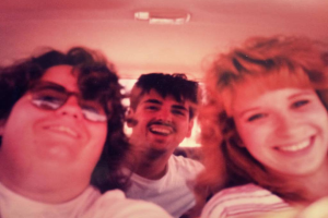 Drei Personen, die jemanden anschauen und lachen.