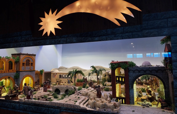 Eine Krippe-Ausstellung im Museum mit beleuchteten Figuren, Tieren und Strukturen, die eine festliche Atmosphäre schaffen.