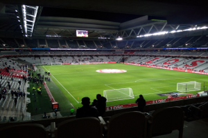 Großes Stadion voller Zuschauer bei einem Fuballspiel im Estadio Santiago Bernabeu in Madrid, Spanien, unter Stadionbeleuchtung mit einem Bildschirm öberkopf.