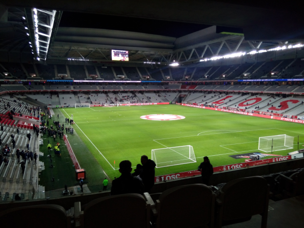 Großes Stadion voller Zuschauer bei einem Fuballspiel im Estadio Santiago Bernabeu in Madrid, Spanien, unter Stadionbeleuchtung mit einem Bildschirm öberkopf.