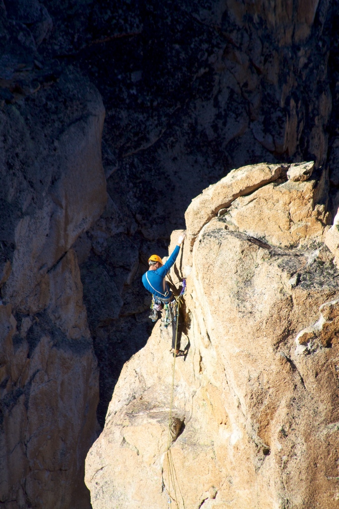 Eine Ausstellung mit Fahrgeschäften, Buden und Menschen unter einem bewölkten Himmel, mit sichtbaren Pfählen, Brettern, Geländern und verschiedenen Gegenständen.