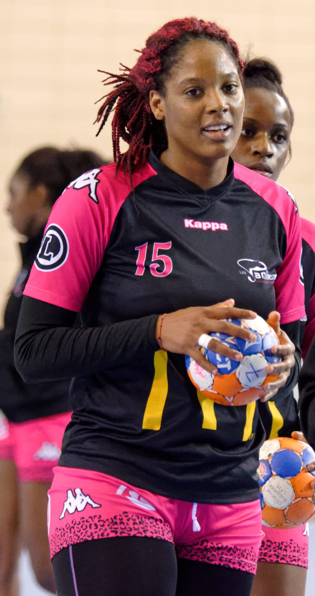 Eine Gruppe von Frauen mit Fußballen, wobei die zentrale Figur ein menschliches Gesicht, einen Pferdeschwanz, ein weißes T-Shirt und blaue Shorts hat.
