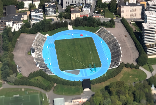 Luftbild des Olympiastadions in München, Deutschland, umgeben von Gebäuden, Bäumen, Straßen, Fahrzeugen und Gras.