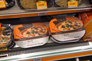 Lebensmittelboxen mit Preisschildern auf Regalen.