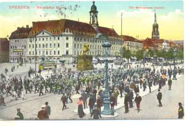 Eine alte Ansichtskarte zeigt einen belebten Stadtplatz in Dresden, Deutschland, mit Menschen, einem zentralen Denkmal und Gebäuden mit Fenstern im Hintergrund unter einem bewölkten Himmel, zusammen mit Text auf der Ansichtskarte.