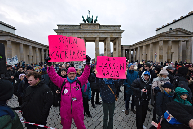 Gruppe von Menschen mit Schildern vor dem Reichstagsgebäude in Berlin, Deutschland, protestiert gegen die anti-nazistische Bewegung der deutschen Regierung.
