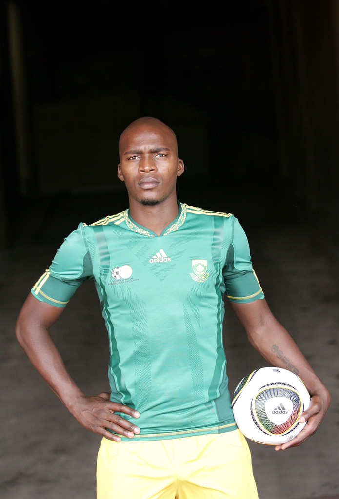 Ein Mann in einem Fußballtrikot, der einen Fußball in der Hand hält.