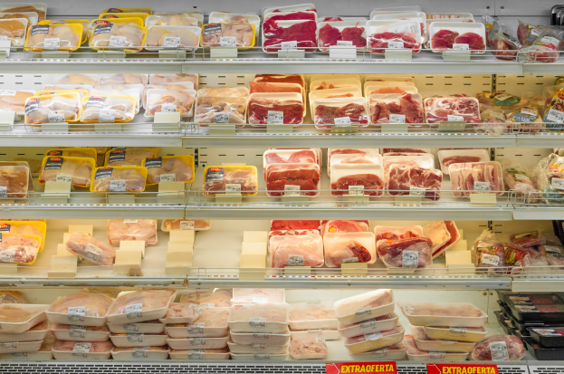 Ein gut sortierter Supermarkt mit ordentlich aufgereihten Fleischwaren auf den Regalen, jeweils mit Preisschildern versehen.